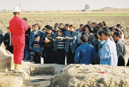 Safar Explaining Borsunlu Bronze Age Kurgan to a school party from the the local village